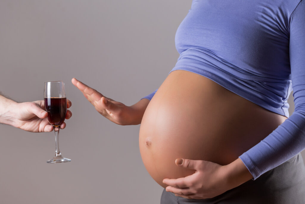Pregnant woman refusing wine